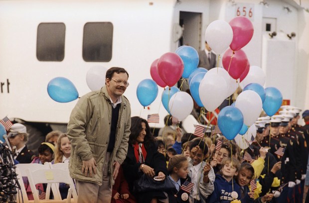 FILE - Former hostage Terry Anderson, accompanied by his daughter Sulome, not shown, and her mother, Madeleine Bassil, arrives to a festive welcome, Dec. 12, 1991, at Dulles International Airport in Chantilly, Va. Anderson, the globe-trotting Associated Press correspondent who became one of America's longest-held hostages after he was snatched from a street in war-torn Lebanon in 1985 and held for nearly seven years, died Sunday, April 21, 2024, at age 76. (AP Photo/Barry Thumma, File)