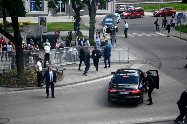 Bodyguards take Slovak Prime Minister Robert Fico in a car from the scene after he was shot and injured following the cabinet's away-from-home session in the town of Handlova, Slovakia, Wednesday, May 15, 2024. Fico is in life-threatening condition after being wounded in a shooting Wednesday afternoon, according to his Facebook profile. (Radovan Stoklasa/TASR via AP)