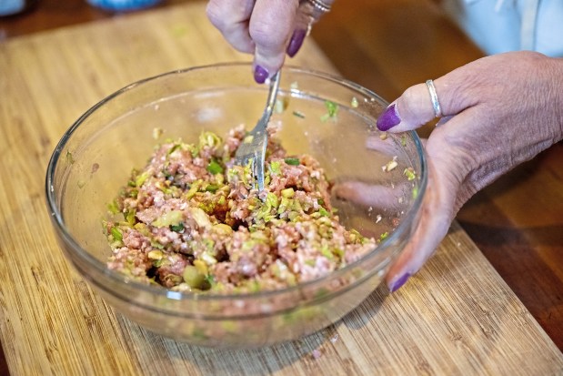 Gretchen McKay mixes homemade dumpling filling in her kitchen on Wednesday, April 3, 2024, in Avon. (Benjamin B. Braun/Pittsburgh Post-Gazette/TNS)