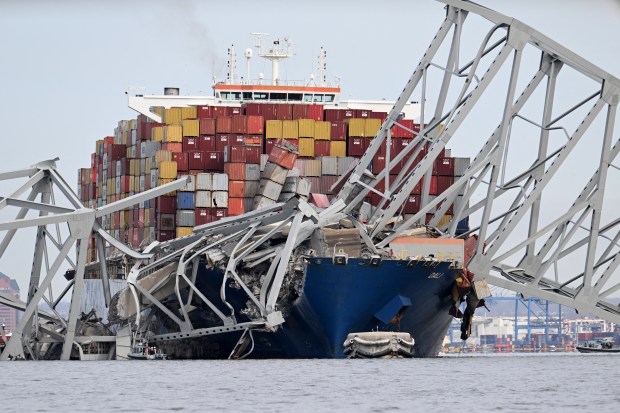 TOPSHOT - The steel frame of the Francis Scott Key Bridge sits on top of the container ship Dali after the bridge collapsed, Baltimore, Maryland, on March 26, 2024. The bridge collapsed early March 26 after being struck by the Singapore-flagged Dali, sending multiple vehicles and people plunging into the frigid harbor below. There was no immediate confirmation of the cause of the disaster, but Baltimore's Police Commissioner Richard Worley said there was "no indication" of terrorism. (Photo by Jim WATSON / AFP) (Photo by JIM WATSON/AFP via Getty Images)
