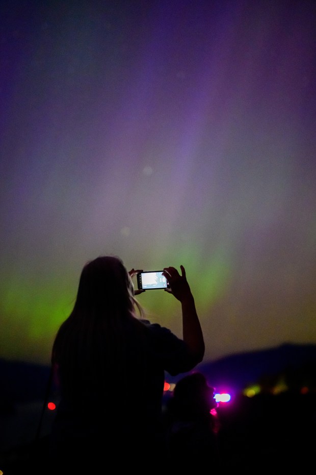 LATOURELL, OREGON - MAY 11: A woman photographs the Northern Lights at Chanticleer Point Lookout on the Columbia River Gorge in the early morning hours of May 11, 2024 in Latourell, Oregon. Places as far south as Alabama and parts of Northern California were expected to see the aurora borealis, also known as the northern lights from a powerful geomagnetic storm that reached Earth. (Photo by Mathieu Lewis-Rolland/Getty Images)