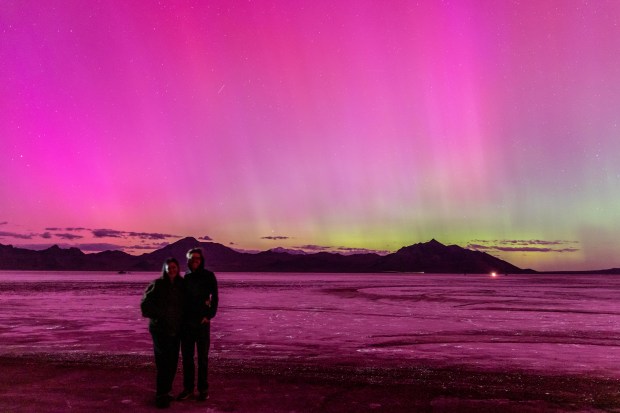 WENDOVER, UTAH - MAY 10: People pose for photos as a geomagnetic storm lights up the night sky above the Bonneville Salt Flats on May 10, 2024 in Wendover, Utah. Places as far south as Alabama and parts of Northern California were expected to see the aurora borealis, also known as the northern lights from a powerful geomagnetic storm that reached Earth. (Photo by Blake Benard/Getty Images)
