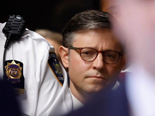 Speaker of the House Mike Johnson listens as former President Donald Trump speaks to reporters as he arrives to attend his trial for allegedly covering up hush money payments linked to extramarital affairs, at Manhattan Criminal Court in New York City, on May 14, 2024. (MICHAEL M. SANTIAGO/POOL/AFP via Getty Images)