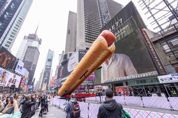 A giant hot dog, part of "Condiment Wars," is installed in Times Square on Tuesday, April 30, 2024. (Michael Hull)