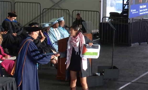 A Columbia University graduate in zip ties is pictured on stage at the social work graduation ceremony. (Columbia University)