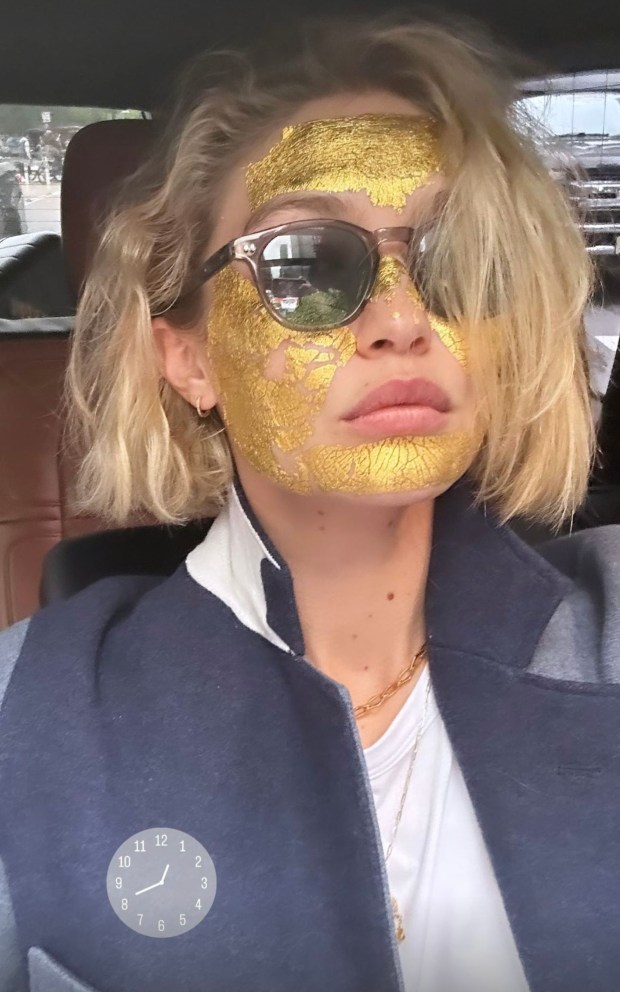 Gigi Hadid gets a gold face mask ahead of the Met Gala on Monday, May 6, 2024.
