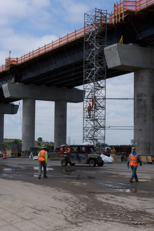 Workers climb to the top of the new structure that will become the North Portal Bridge.