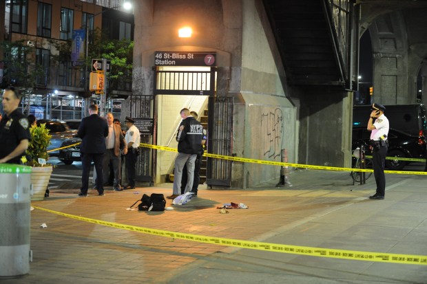 Police on the scene where the victim was fatally stabbed outside the 46th St.-Bliss Street station Wednesday. (Sam Costanza for the New York Daily News)